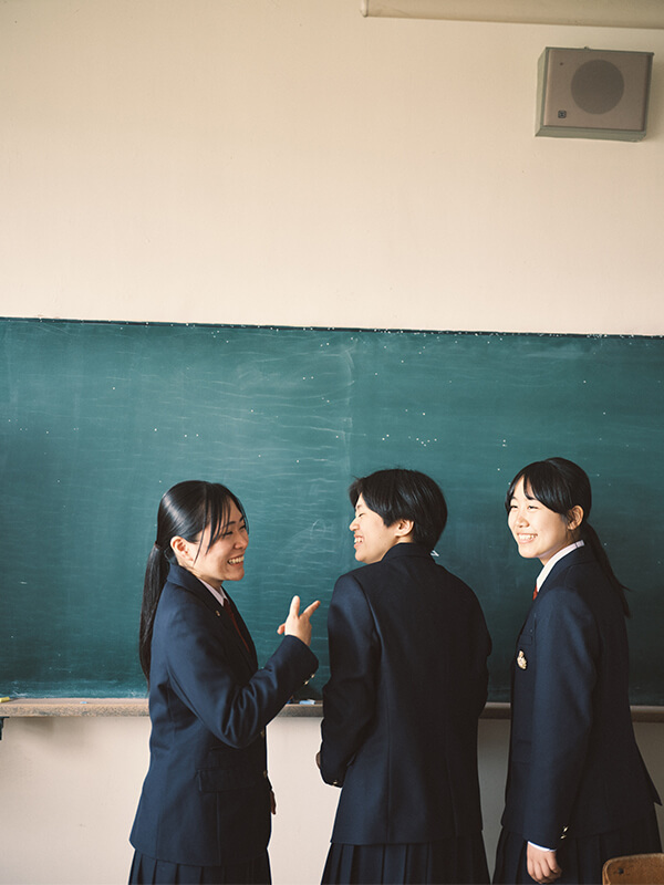 教室で談笑する制服姿の生徒