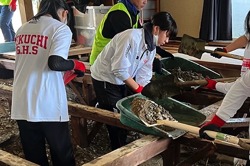 災害復旧ボランティアで建物内の土砂を運び出す生徒たち