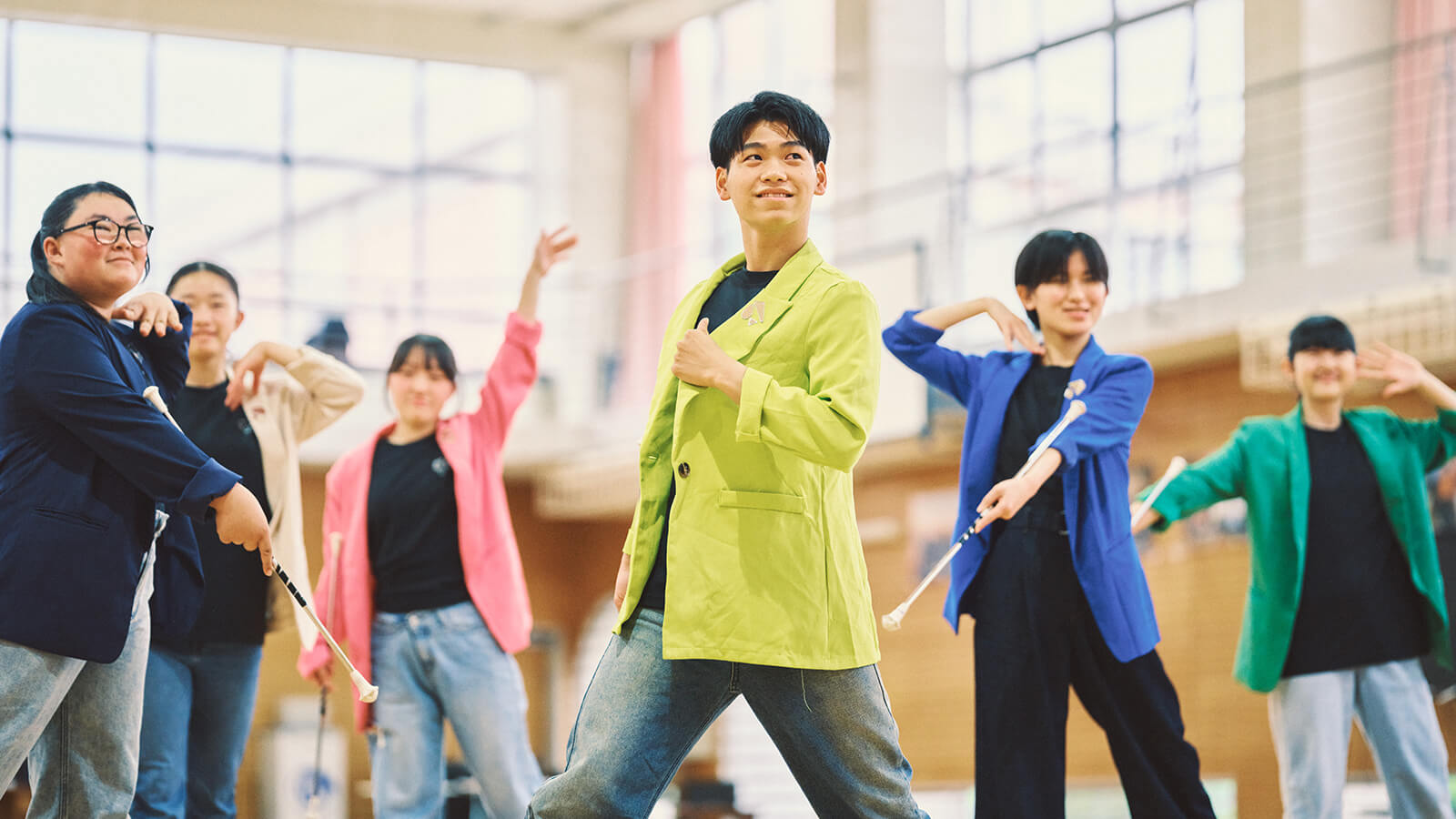 体育館で色鮮やかな衣装を着て活動する生徒たち