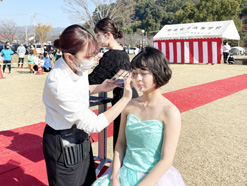 菊女フェスタのヘアメイクショーでメイクを施す生徒