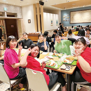 修学旅行先で食事を囲んで笑顔を見せる生徒たち