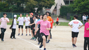 スポーツフェスタの競技で校庭を走る生徒たち