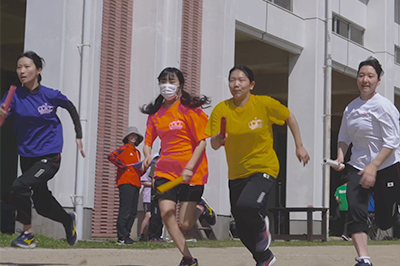 スポーツフェスタで校庭を走る参加者たち