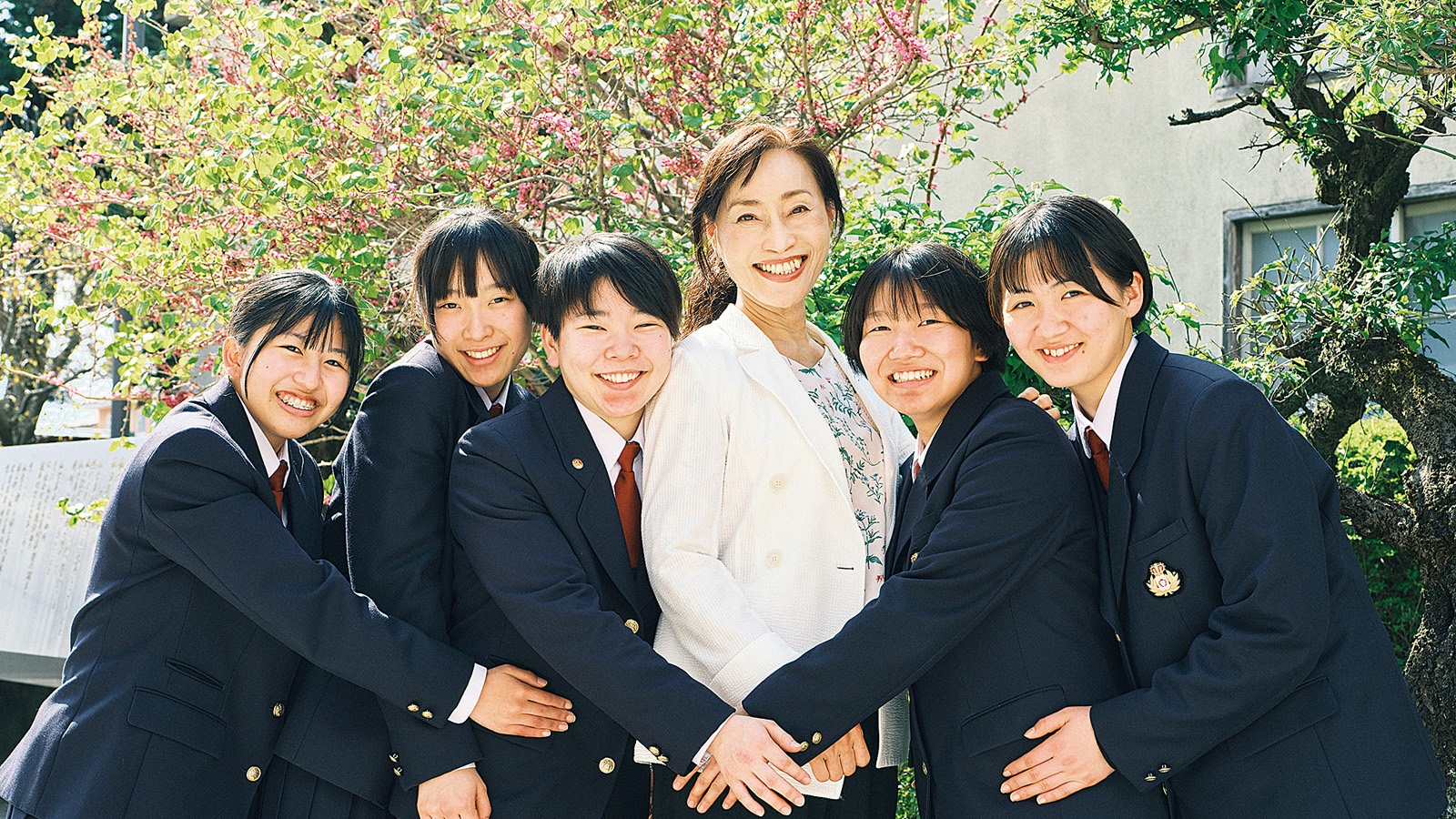 学校長と笑顔で寄り添う生徒たち